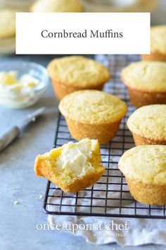 several muffins on a cooling rack with butter and icing next to them