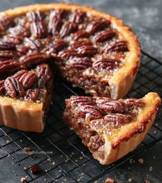 a pecan pie on a cooling rack with one slice cut out and ready to be eaten