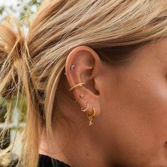 a close up of a person wearing earring in the shape of a star with two small stars on it