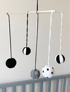 three black and white balls hanging from a crib