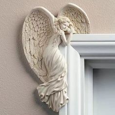 an angel figurine hanging on the side of a wall