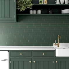 a kitchen with green cabinets and white sink