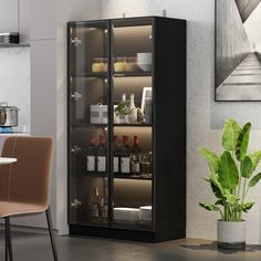 a glass door cabinet with bottles and glasses on it next to a dining room table