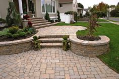 a brick patio with steps leading up to the house