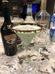 a martini sitting on top of a counter next to bottles