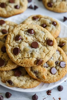 chocolate chip cookies are stacked on a white plate