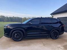 a black suv parked in front of a garage