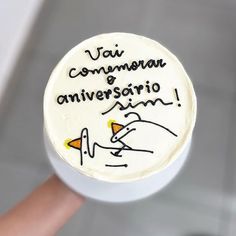 a hand holding a cake with writing on it