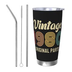 a stainless steel straw next to a black tumbler with the words vintage 1950 on it