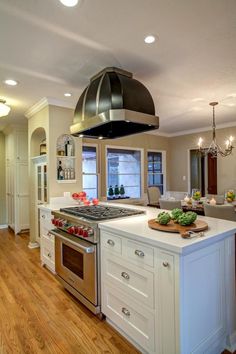 a kitchen with an island, stove and oven in the middle of it's center island