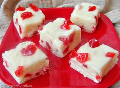 four pieces of cake on a red plate with white frosting and jelly toppings