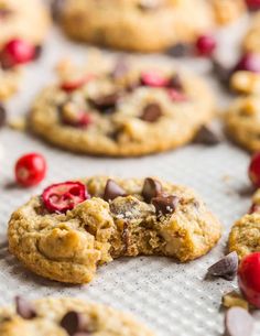 cookies with cherries and chocolate chips on a baking sheet, ready to be eaten