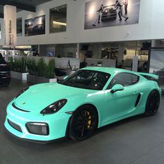 a blue porsche sports car parked in a showroom