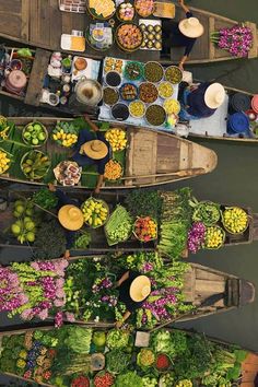 two boats filled with lots of food on top of a river next to each other