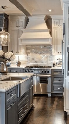 a large kitchen with white cabinets and stainless steel appliances, along with hardwood flooring