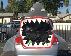 the back end of a car with a fake shark head on it's trunk