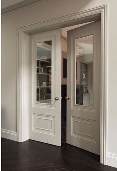 two white doors in a room with wood floors