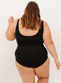 This is our top-selling one-piece style! Featuring a scooping back and a scoop front with ties that knot under the bust, this suit is sure to become an instant favorite. We are confident you will love it! 80% nylon, 20% spandexProvides UV 50+ protectionDouble-lined shelf bra with foam cups (excluding size XXS, which has no padding)Sewn in the USA / Imported fabric Available in XXS-4X A portion of proceeds from this suit goes to bringing clean water to developing countries. Learn how your purchas Fitted Bra-friendly Swimwear With Scoop Back, Scoop Back Bodysuit With Built-in Bra For Swimming, Scoop Back Bodysuit With Built-in Bra For Swimwear, Black Racerback Swimwear With Moisture-wicking, Black Elastane Swimwear With Built-in Bra, Foam Cups, Beautiful Suit, Shelf Bra, Developing Country