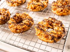 there are many donuts with chocolate drizzles on them sitting on a cooling rack