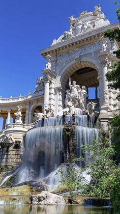 an ornate building with a waterfall in the foreground