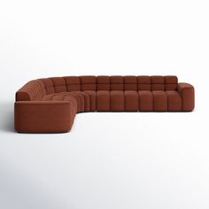 a brown sectional couch sitting on top of a white floor