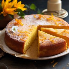 a cake that is sitting on a plate with slices taken out of it and flowers in the background