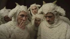 a group of men dressed in white sheep suits with horns on their heads and noses