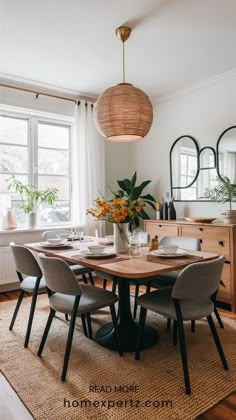 a dining room table with four chairs and a vase on top of it, in front of a window