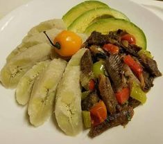 a white plate topped with sliced vegetables and meat