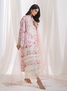 A sophisticated powder pink floral suit, this ensemble exemplifies grace features a soft, pink fabric adorned with subtle, intricate floral prints that provide a gentle contrast, imbuing the piece with a spring-like freshness. The standout feature is the meticulous white hem embroidery, which traces the borders with fine, elegant detailing. Complementing with fine organza dupatta. This suit is ideal for occasions making it a perfect choice for formal events or stylish social gatherings. Shirt: P Floral Pakistani Suits, Feminine Silk Sets For Summer, Pink Silk Floral Print Sets, Elegant Pink Lawn Suit For Formal Occasions, Feminine Silk Sets For Spring, White Feminine Sets For Spring, Feminine Floral Embroidered Sets For Spring, Feminine Floral Embroidered Spring Sets, Pink Floral Embroidered Lawn Suit For Summer