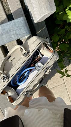 a person holding a piece of luggage with scissors in it's pocket while sitting on a bench