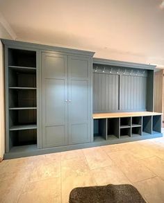 an empty room with several shelves and cabinets in it, including a bench on the far wall