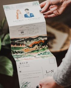 a person holding up a wedding card in their hand