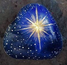 a blue rock with white dots and a yellow star painted on the top is shown