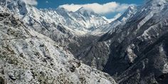 the mountains are covered in snow and clouds