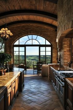 a large kitchen with an arched window overlooking the countryside