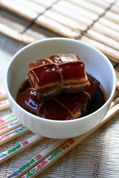 there is some food in the bowl and chopsticks next to it