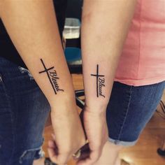 two people holding hands with cross tattoos on them