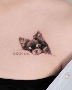 a small dog tattoo on the back of a woman's stomach