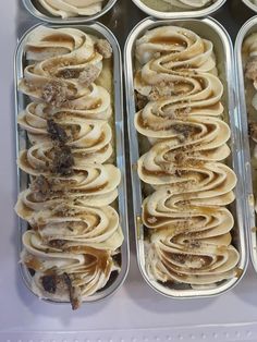 four trays filled with food sitting on top of a white countertop next to each other