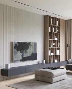 a living room with a large television mounted on the wall next to a book shelf