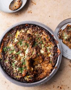 a pizza sitting in a pan on top of a table next to a fork and spoon