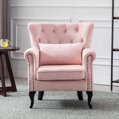 a pink chair sitting on top of a carpeted floor