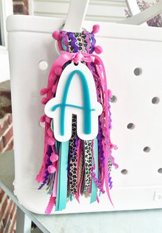 a white bag with pink, blue and purple hair clips hanging from it's handle