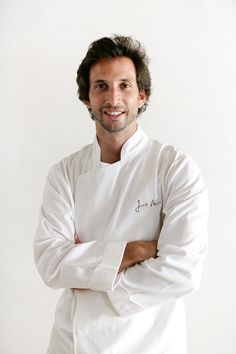 a man wearing a chef's coat with his arms crossed in front of him