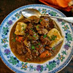 a blue and white plate topped with stew