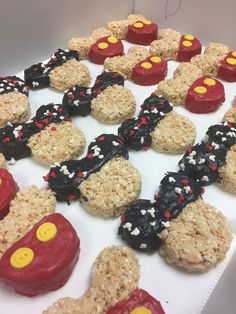 mickey mouse rice krispy treats are arranged on a white tablecloth with red, yellow and black frosting