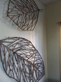 two metal leaves are hanging on the wall