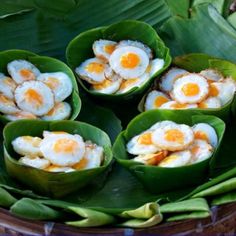 some food is sitting in the middle of green leafy bowls on top of each other