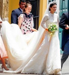 the bride and groom are walking down the street